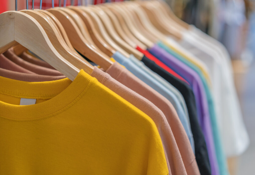 multi-colored clothes on hangers in store